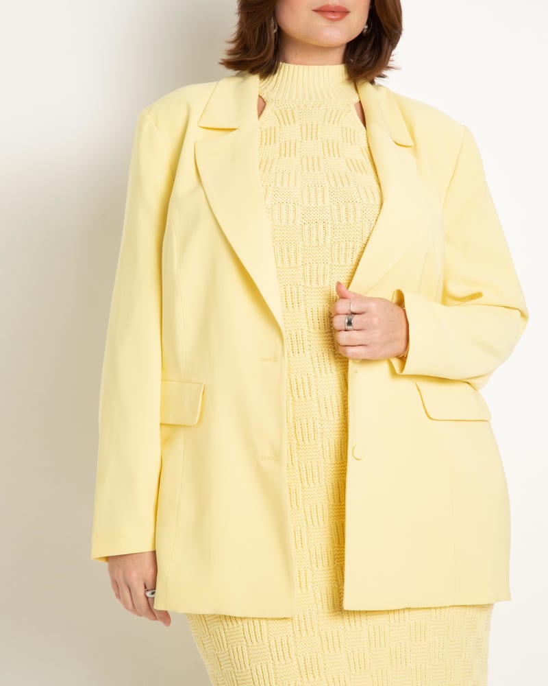 Front of a model wearing a size 28 Sleek Blazer in Lemon Meringue by ELOQUII. | dia_product_style_image_id:273008